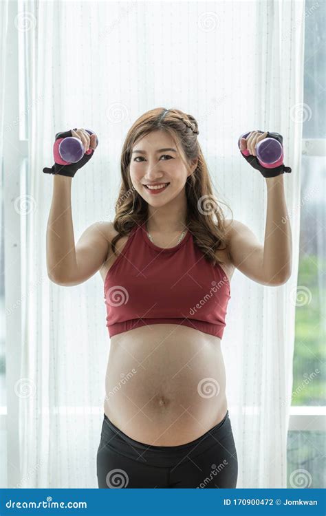 Happy Beautiful Attractive Pregnant Asian Woman Standing Near Windows And Workout Exercising