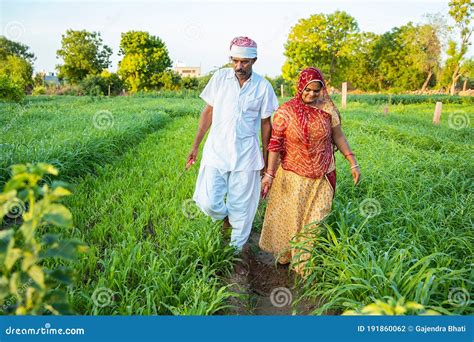 Indian Farmer Couple Walking Together In Their Agriculture Green Field