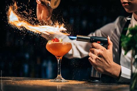 Bartender Spilling And Burning Spices Over Cocktail By Stocksy Contributor David Prado