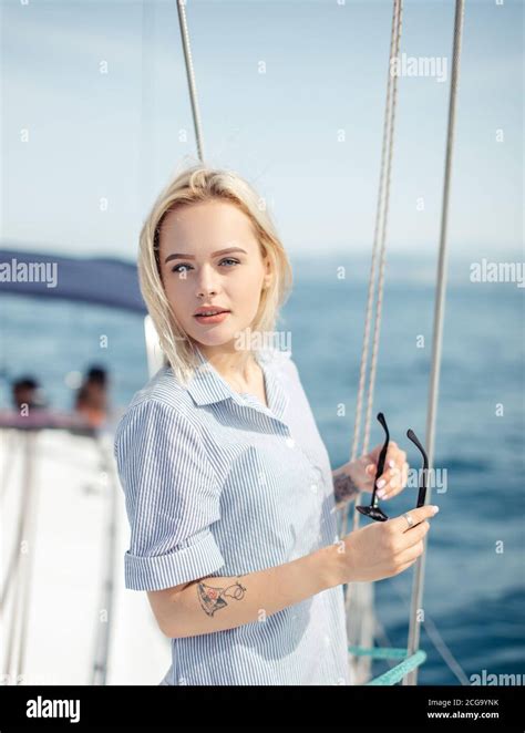 Outdoor Portrait Of Beautiful Young Woman Standing On The Deck Of A Sailing Boat With Raised