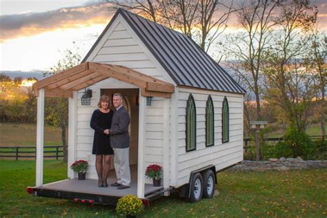 Two People Standing In The Doorway Of A Tiny House