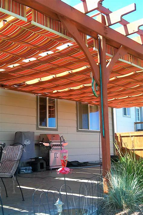 Wood Pergola With Added Striped Shade Runners On Slide Wires