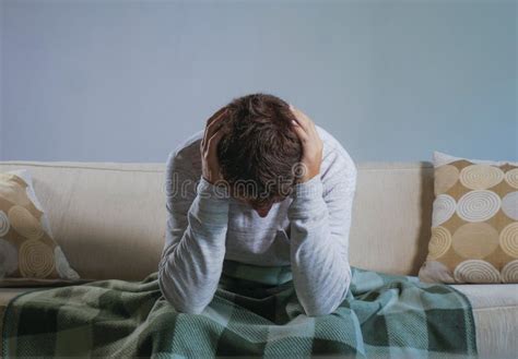 Young Sad And Desperate Man At Home Sitting At Living Sofa Couch