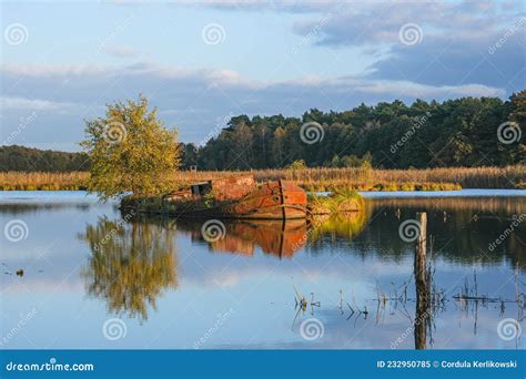 Rusty Abandoned Ship In A Little Lake Surrounded By Meadows Stock