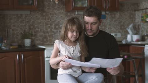 Dad Watches The Drawings Of His Daughter Who Sits On His Lap Slow