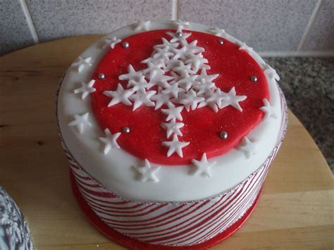 A Red And White Decorated Cake Sitting On Top Of A Wooden Table