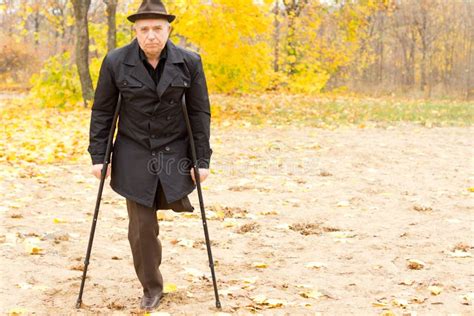 One Legged Man Walking With Crutches In The Park Stock Image Image