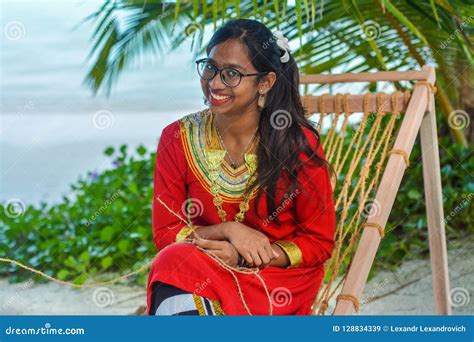 Beautiful Maldivian Woman In National Dress Smiling While Crafting