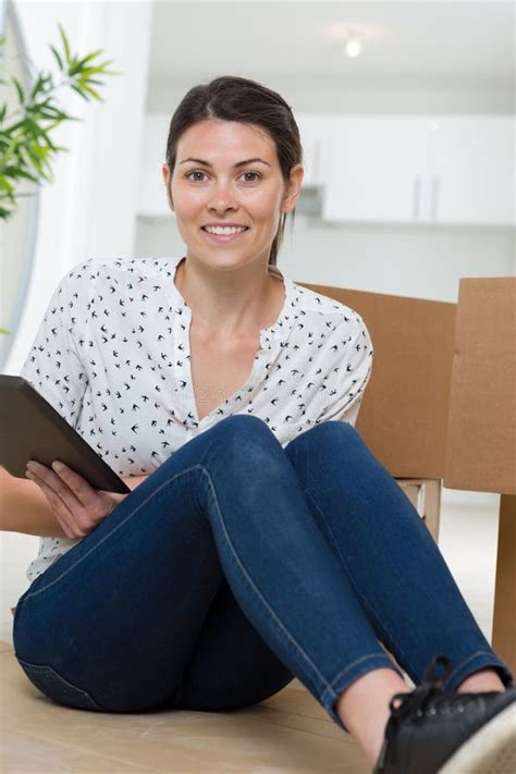 Young Woman Moving House With Cardboard Boxes And Tablet Stock Image