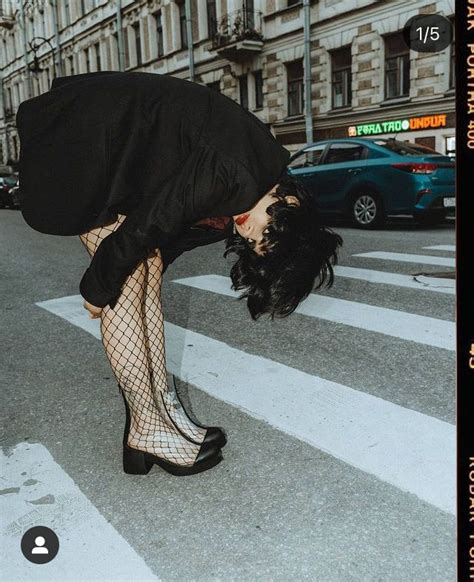 A Woman In Fishnet Stockings Bending Over On The Street