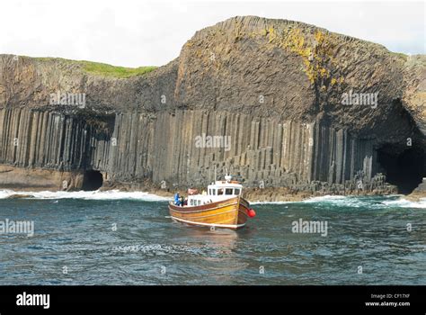A Boat Cruising Alongside The Isle Of Staffa With Fingals Cave And
