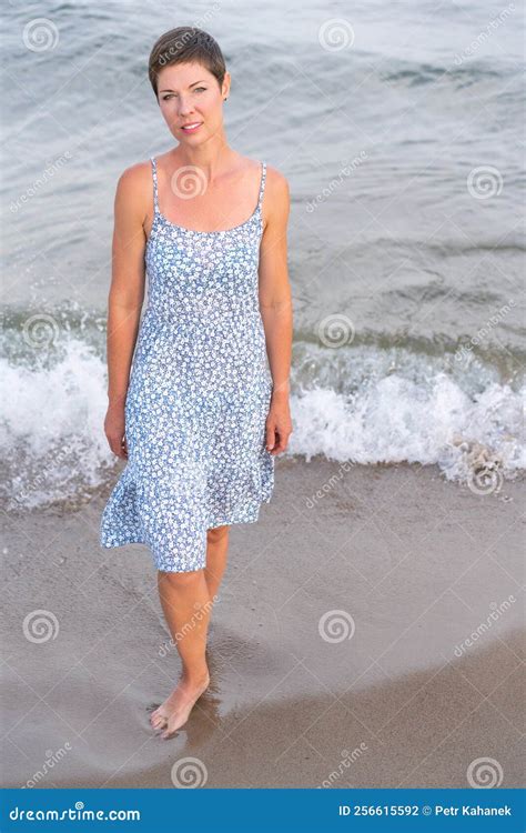 Attractive Short Haired Woman In Her Thirties Wear In Light Summer Dress Walks Barefoot On The