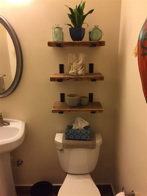 A Bathroom With A Toilet Sink And Shelves On The Wall Above Its Tank