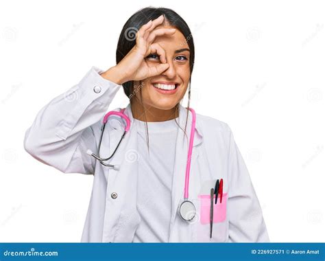 Beautiful Hispanic Woman Wearing Doctor Uniform And Stethoscope Doing Ok Gesture With Hand