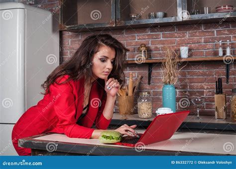 Smart Business Woman Working On Her Laptop At Home In Kitchen Stock