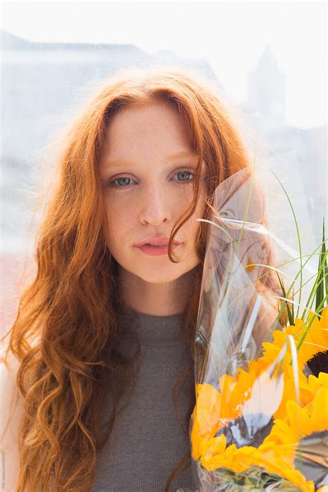 Portrait Of A Beautiful Ginger Hair Woman Holding Sunflowers Del Colaborador De Stocksy