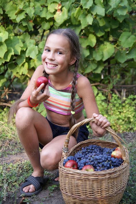 Preteen Girl With Basket Full Of Organic Grapes And Apples Foto De