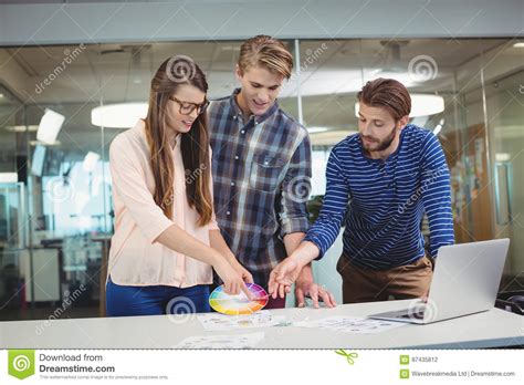 Graphic Designers Interacting With Each Other While Working Stock Photo