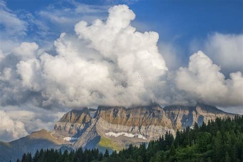 Cumulus Clouds Over Mountain Peaks In The Swiss Alps Stock Photo