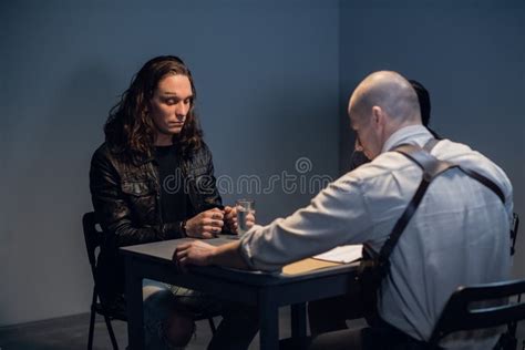 An Experienced Investigator During An Interrogation At A Police Station Shows The Criminal Girl