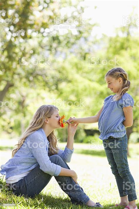 Mother Smelling The Pretty Flower That Her Daughter Has Given Stock
