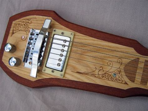 Guitar slide, capo, guitar mute (string muter), guitar pick and guitar pick holder.first. "Lap steel guitar of mahogany inlaid with ash and oak fret markings, paua shell position markers ...