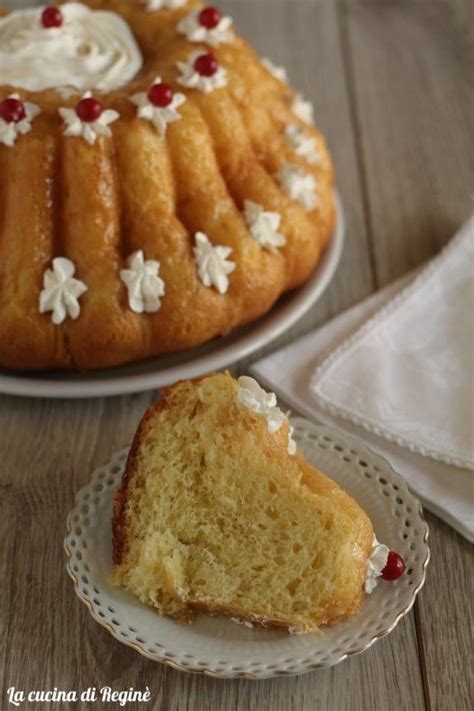 A Bundt Cake With White Frosting And Cherries On It Next To A Plate