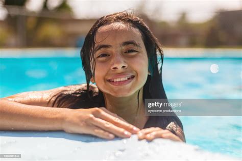 Young Hispanic Female Playing In Swimming Pool Summer Time Fun Photo