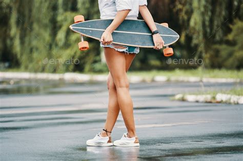 Skater Girl Standing Crossed Legs Holding Her Longboard Behind H Stock