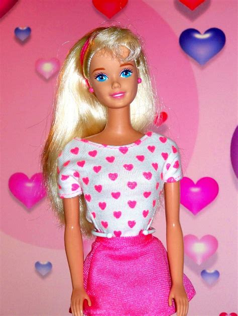 a barbie doll is standing in front of a pink background with hearts on the wall