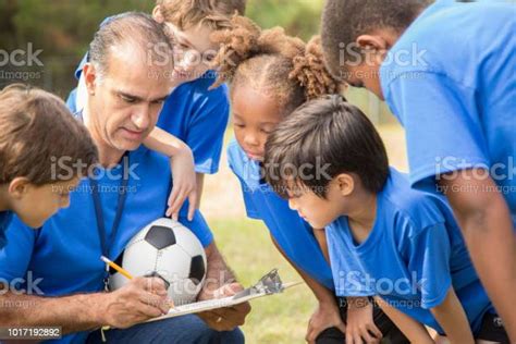 Soccer Team Coach Explains Next Play To His Childrens Team Stock Photo