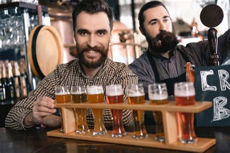 Two Bearded Men Test Beer Of Different Styles In Beer Samplers In
