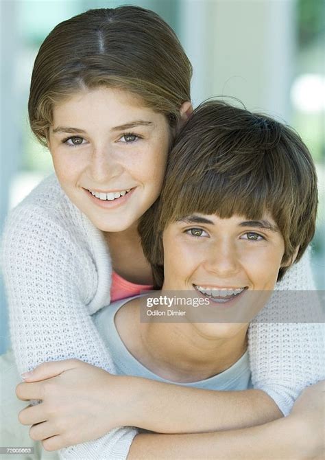 Girl Hugging Preteen Boy From Behind Portrait High Res Stock Photo
