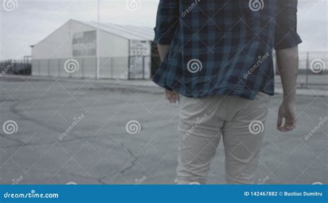 Back View Of A Walking Guy Wearing A Plaid Shirt And Jeans Walking In