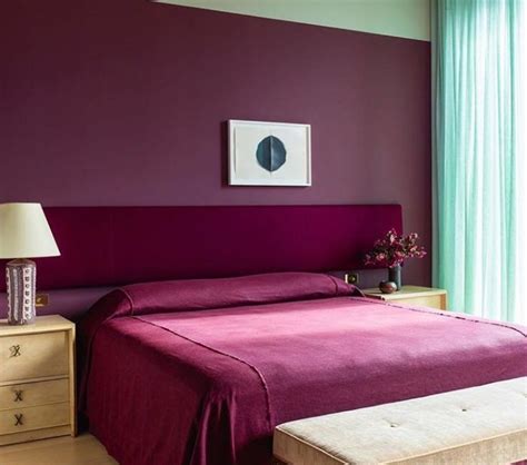 A Bed Room With A Neatly Made Bed And Purple Walls