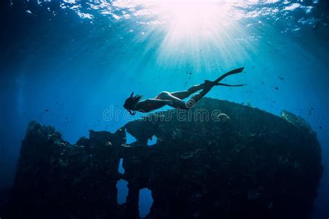 Freediver Girl In Pink Swimwear With Fins Swimming Underwater At Wreck