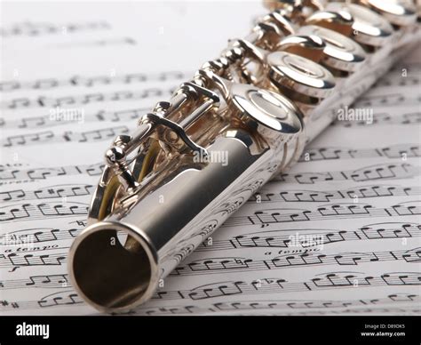A Used Flute Rests Across An Open Musical Score Only One Line Of Music