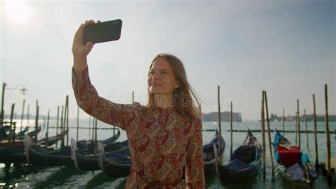 woman takes selfie photos by phone with gondolas in venice in italy europe stock footage