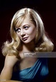 a woman with blonde hair and blue dress posing for a studio portrait ...