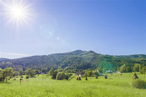 Village Houses On Hills With Green Meadows In Summer Day Stock Image