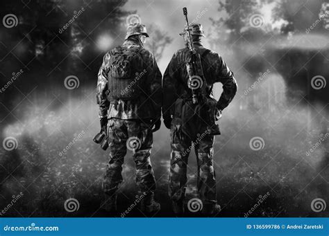 Two Soldiers Of A Special Unit Are Standing In A Smoky Forest Stock