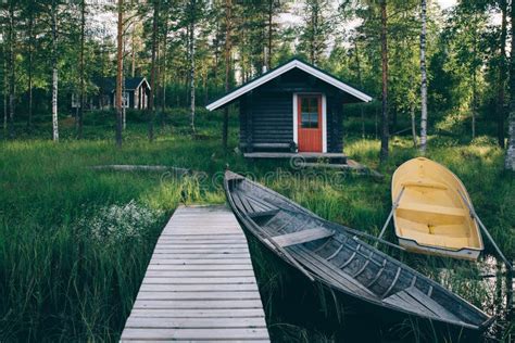 A Traditional Finnish Wooden Cottage With A Sauna And A Barn On The