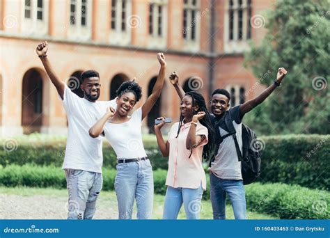 Four Happy African Students Best Friends Standing Near University With