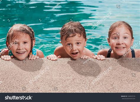 Three Happy Children Playing On The Swimming Pool At The Day Time