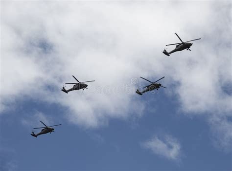 Our Black Hawk Helicopters Flying Over Crowd With Blue And Cloudy Sky