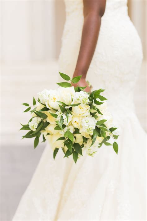 A Bride Holding A Bouquet Of White Flowers