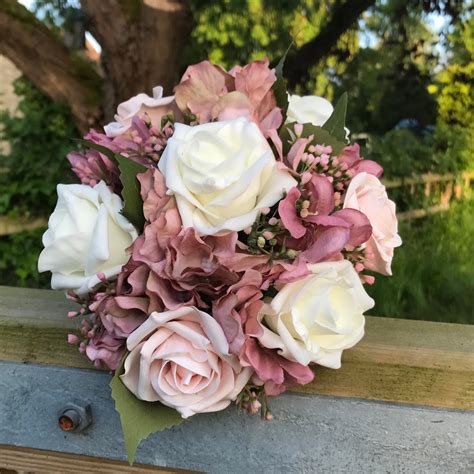 A Wedding Bouquet Collection Featuring Ivory And Pink Rose Flowers