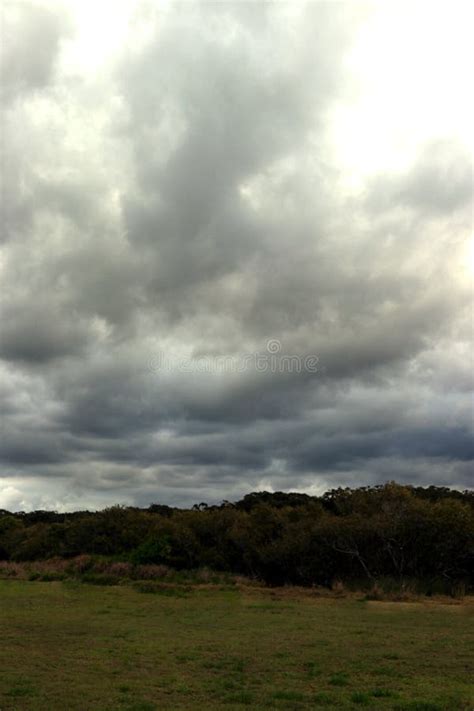 Dramatic Storm Clouds Over Grassy Fields In Portrait Stock Image