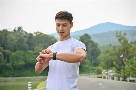 Handsome Asian Man Checking His Calories Burned From Running On His
