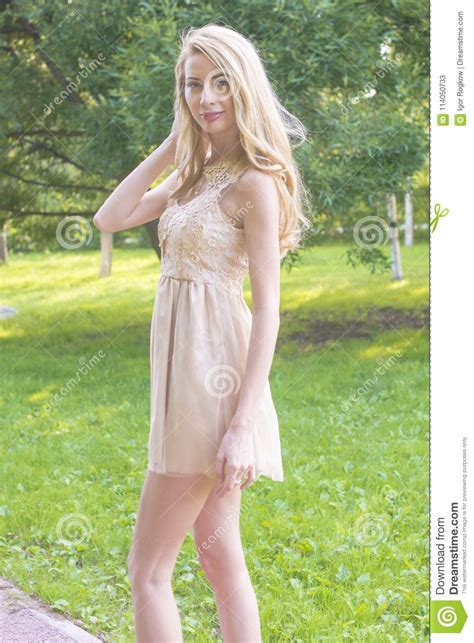 Young Beautiful Blonde Woman In A Beautiful Dress In A Summer Park